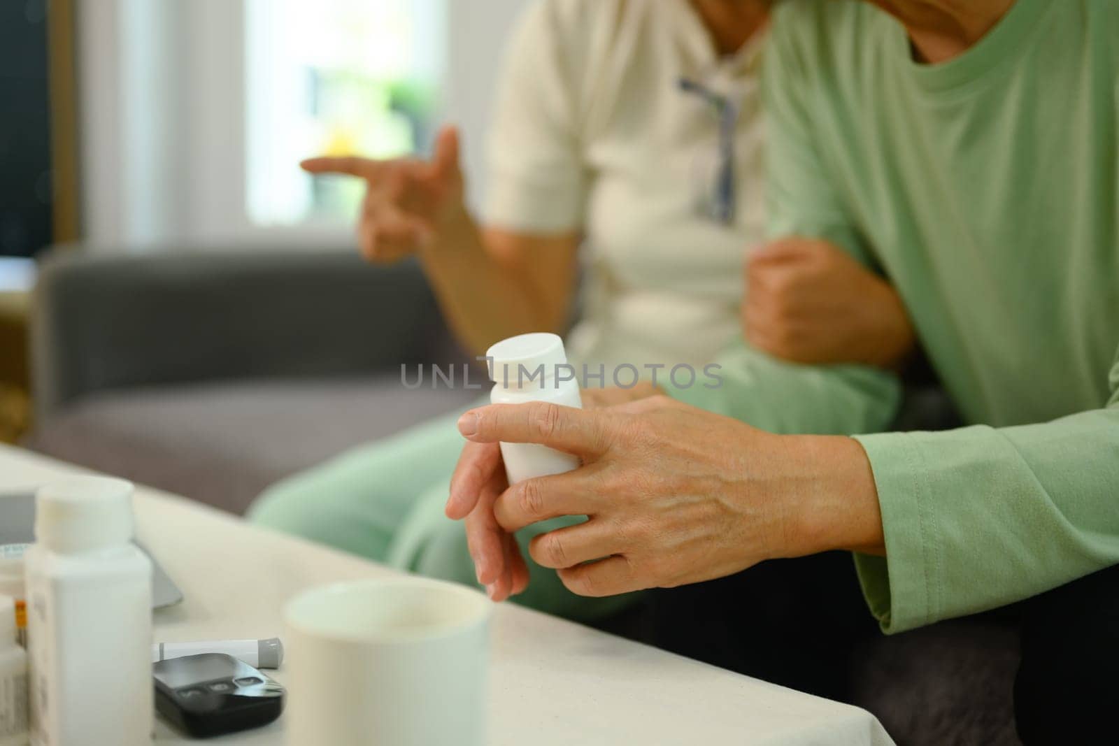 Close up shot of elderly man taking prescription medicine at home. Healthcare concept by prathanchorruangsak