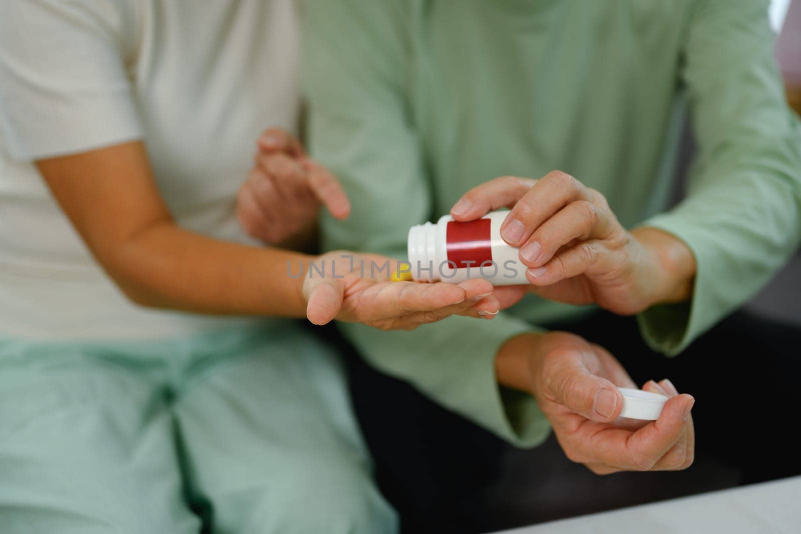 Elderly woman pouring capsules from pill bottle. Healthcare concept.