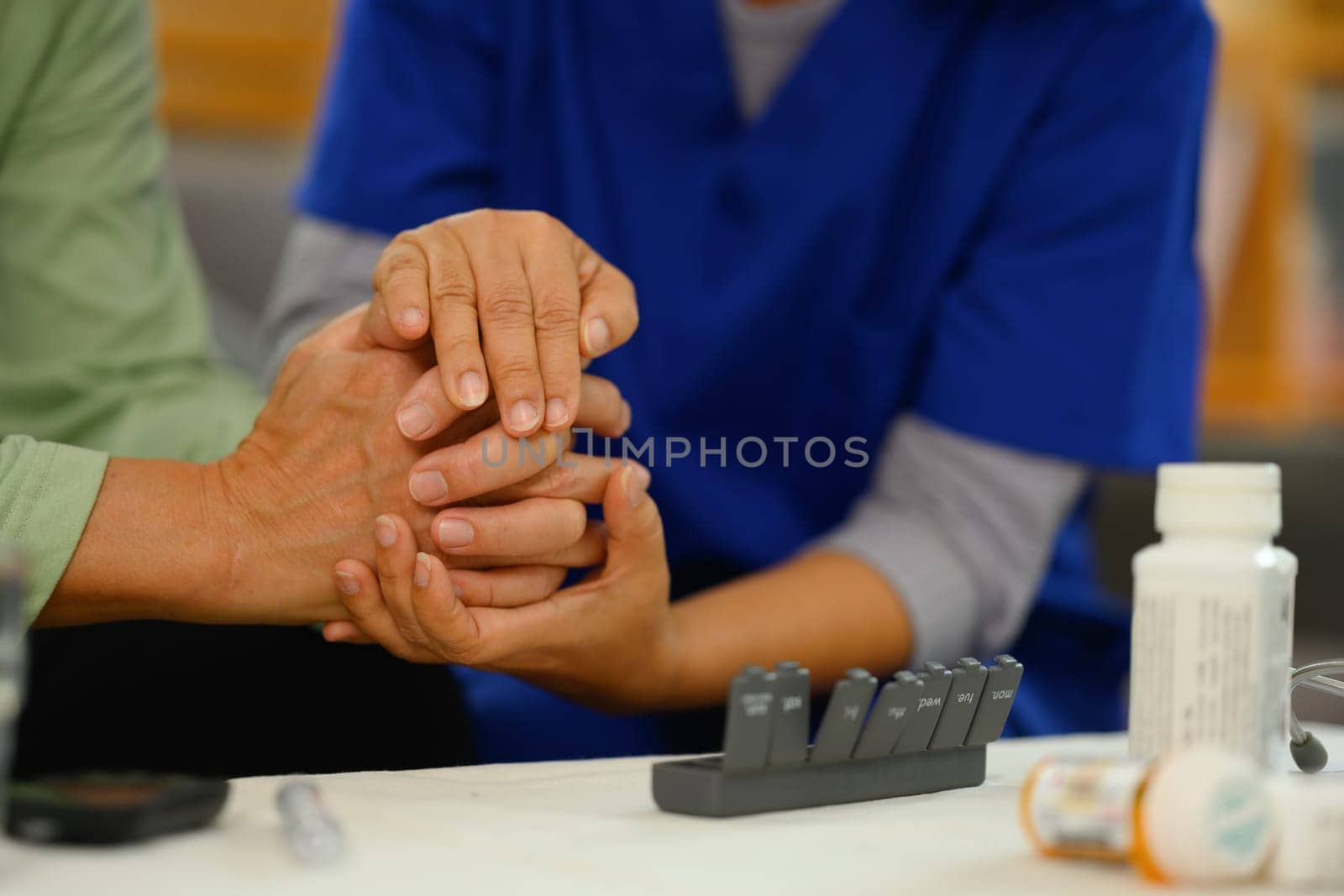 Caring nurse holding hands comforting upset senior patient. Elderly healthcare concept.