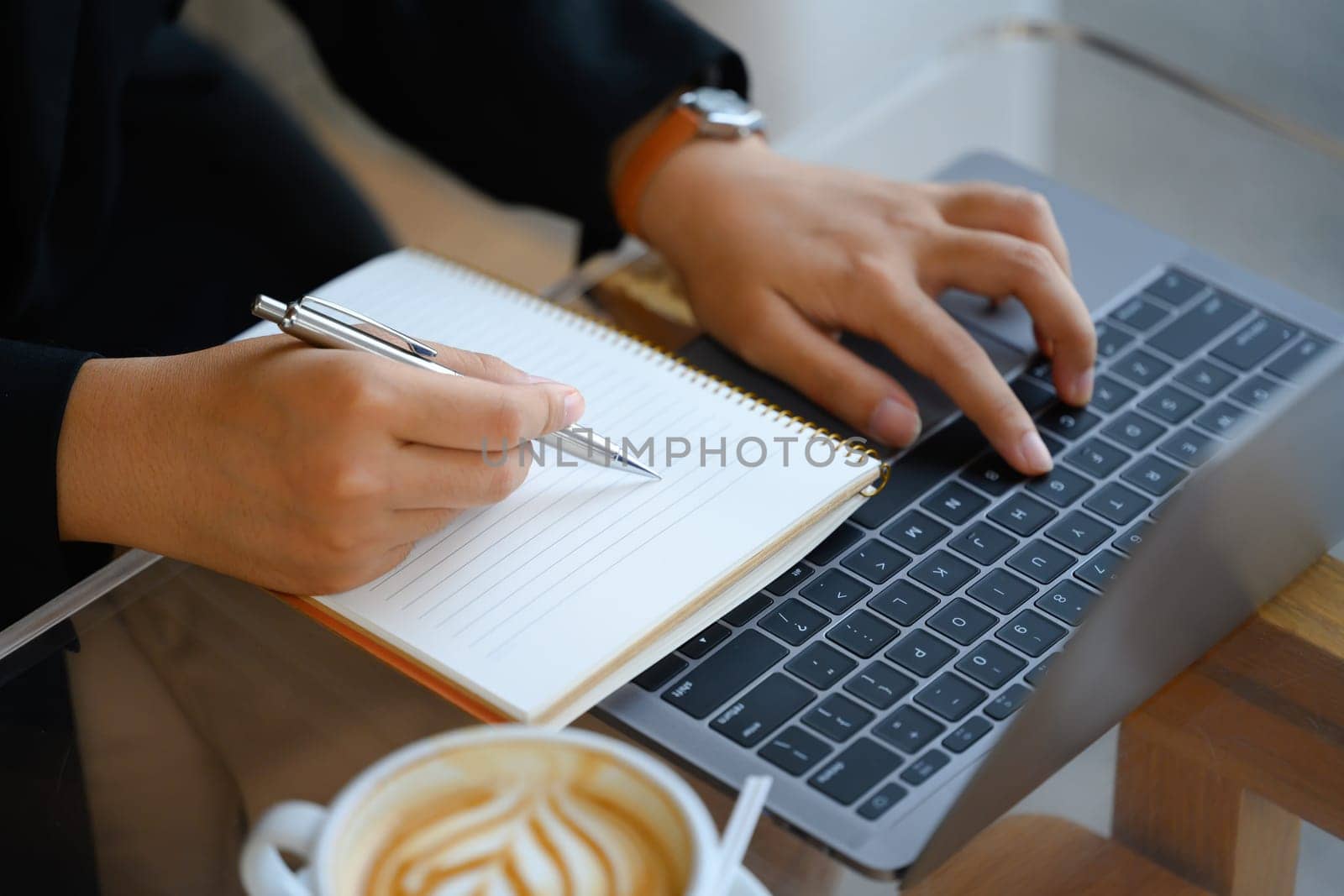 Cropped shot businesswoman writing down ideas or planning next weekend on notebook by prathanchorruangsak