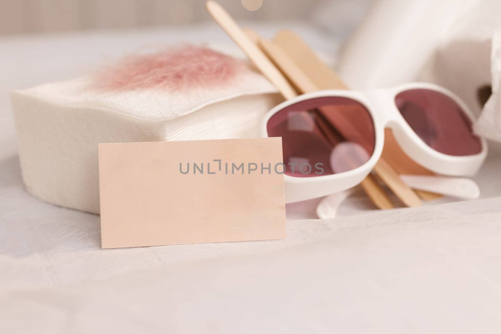Safety glasses, UV protection. Empty business card, credit card or blank paper. Many wax wooden spatulas. The concept of beauty, depilation, waxing, sugaring smooth skin without hair, banner, health by uflypro