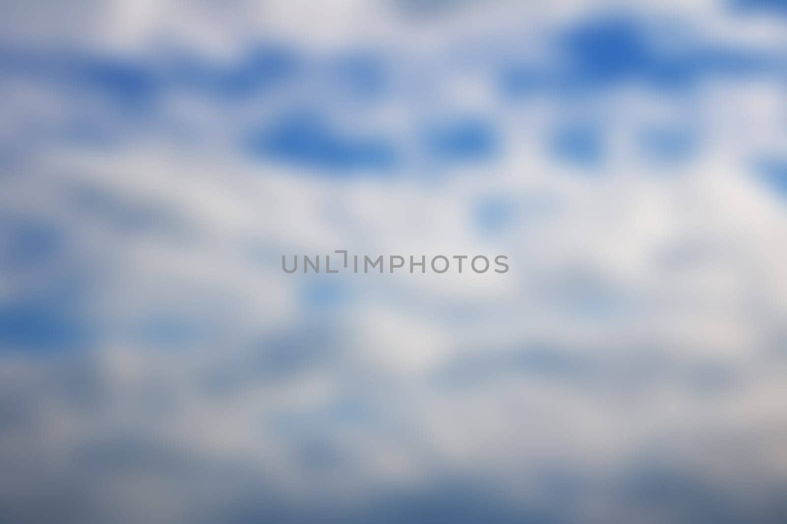 An electric blue sky filled with fluffy white cumulus clouds, creating a beautiful natural landscape pattern. A mesmerizing meteorological phenomenon on the horizon of a stunning landscape