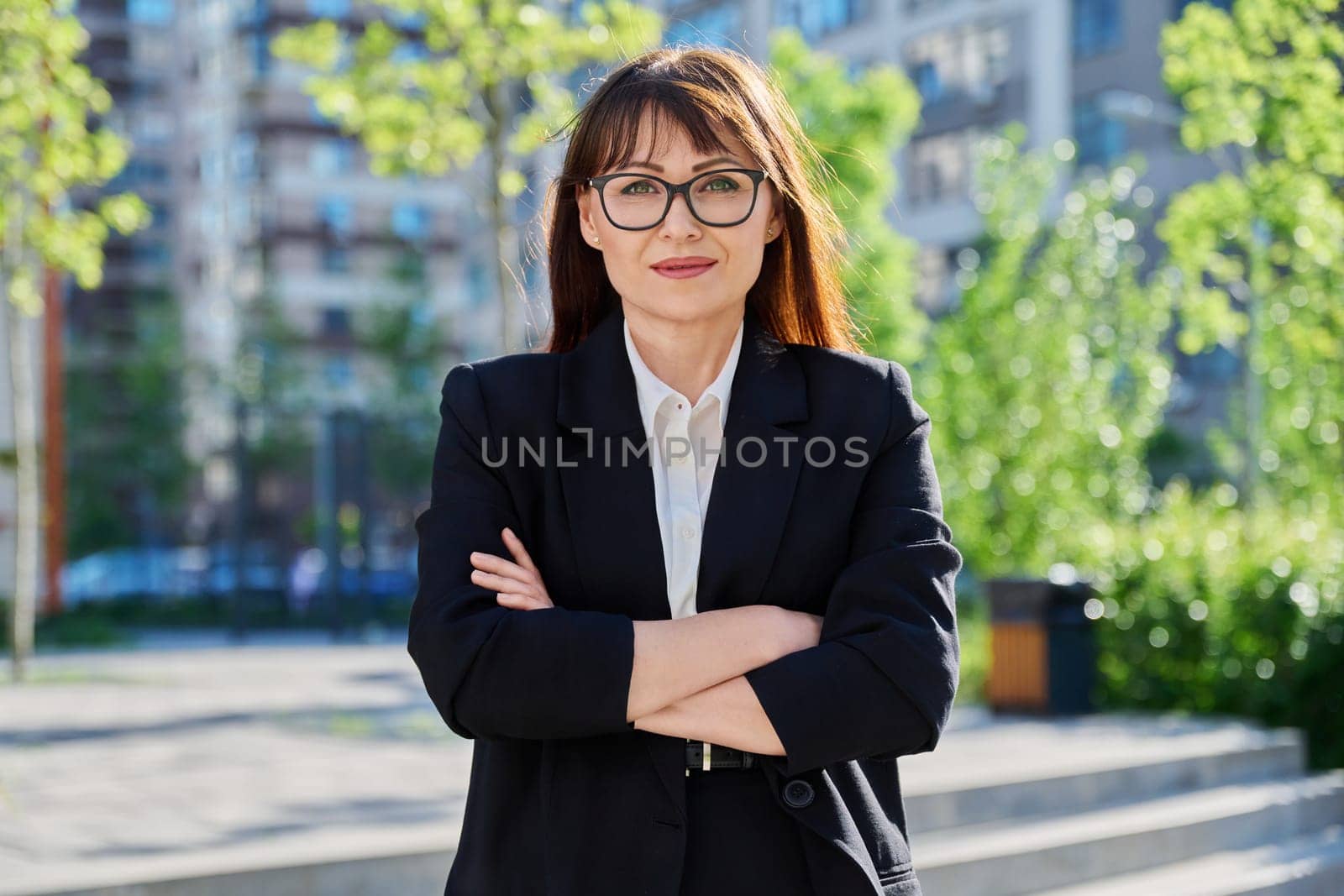Portrait of middle-aged business confident woman in suit, posing outdoors by VH-studio