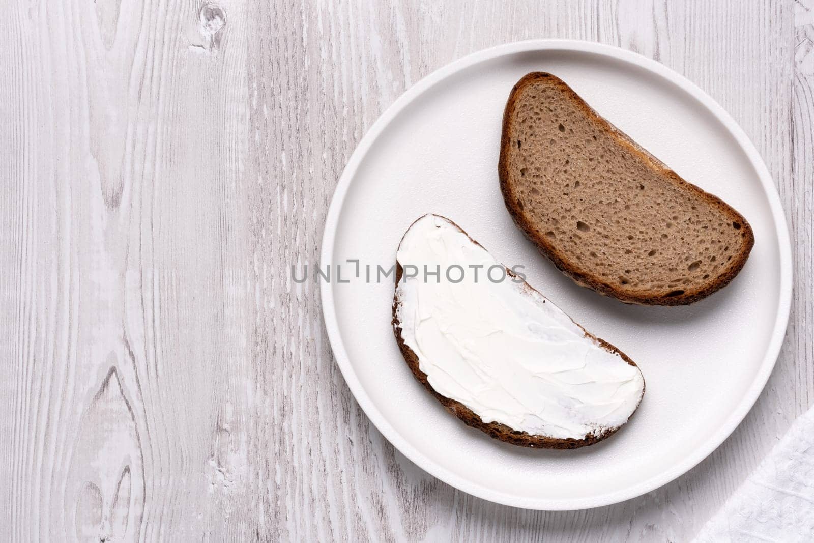 Sandwiches with soft curd cheese on a white wooden table., with copy space for text.