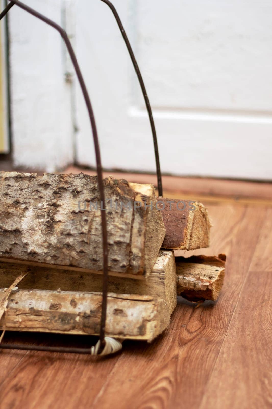 A stack of Brown logs rests on a Hardwood plank flooring. The Wood stain enhances the natural beauty of the Floor