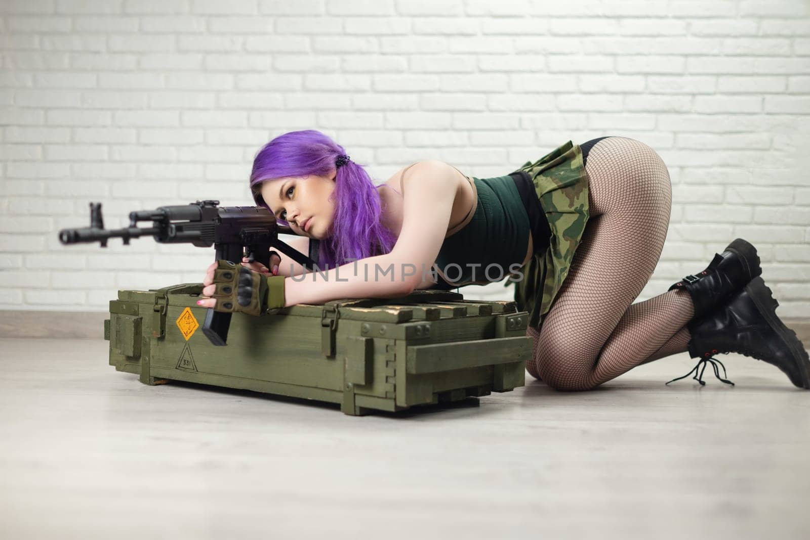 hot girl in a short sexy military skirt with a Kalashnikov assault rifle and a gun case on a brick wall background copy paste by Rotozey
