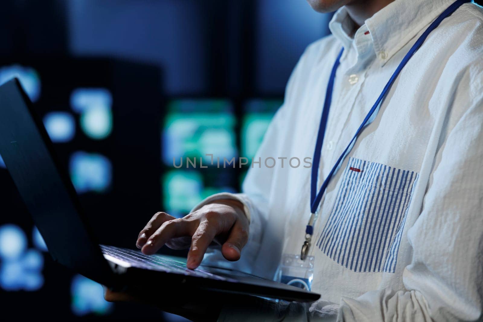 Admin in server room future proofing network from downtimes and unexpected system failures using laptop, close up. Employee ensuring reliable operations and increased data security