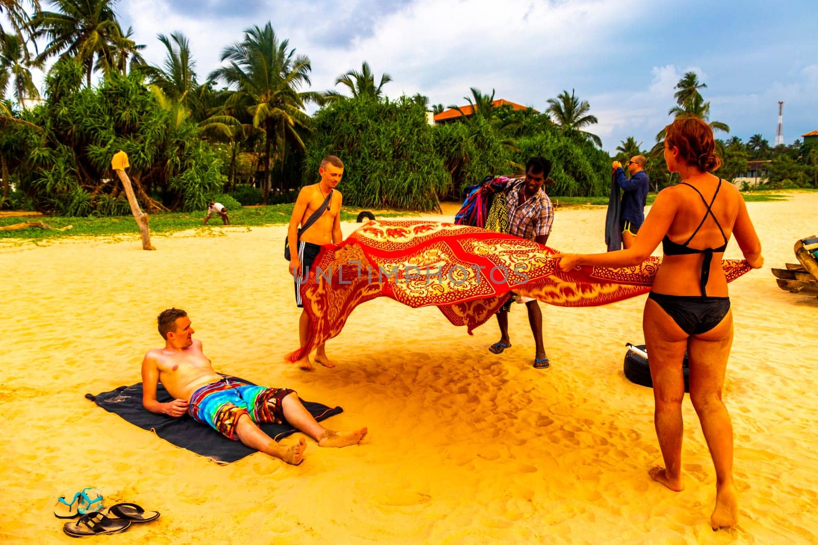 Beautiful beach with tropical nature sand water waves people fun parasols and sun loungers in Bentota Beach on Sri Lanka island.