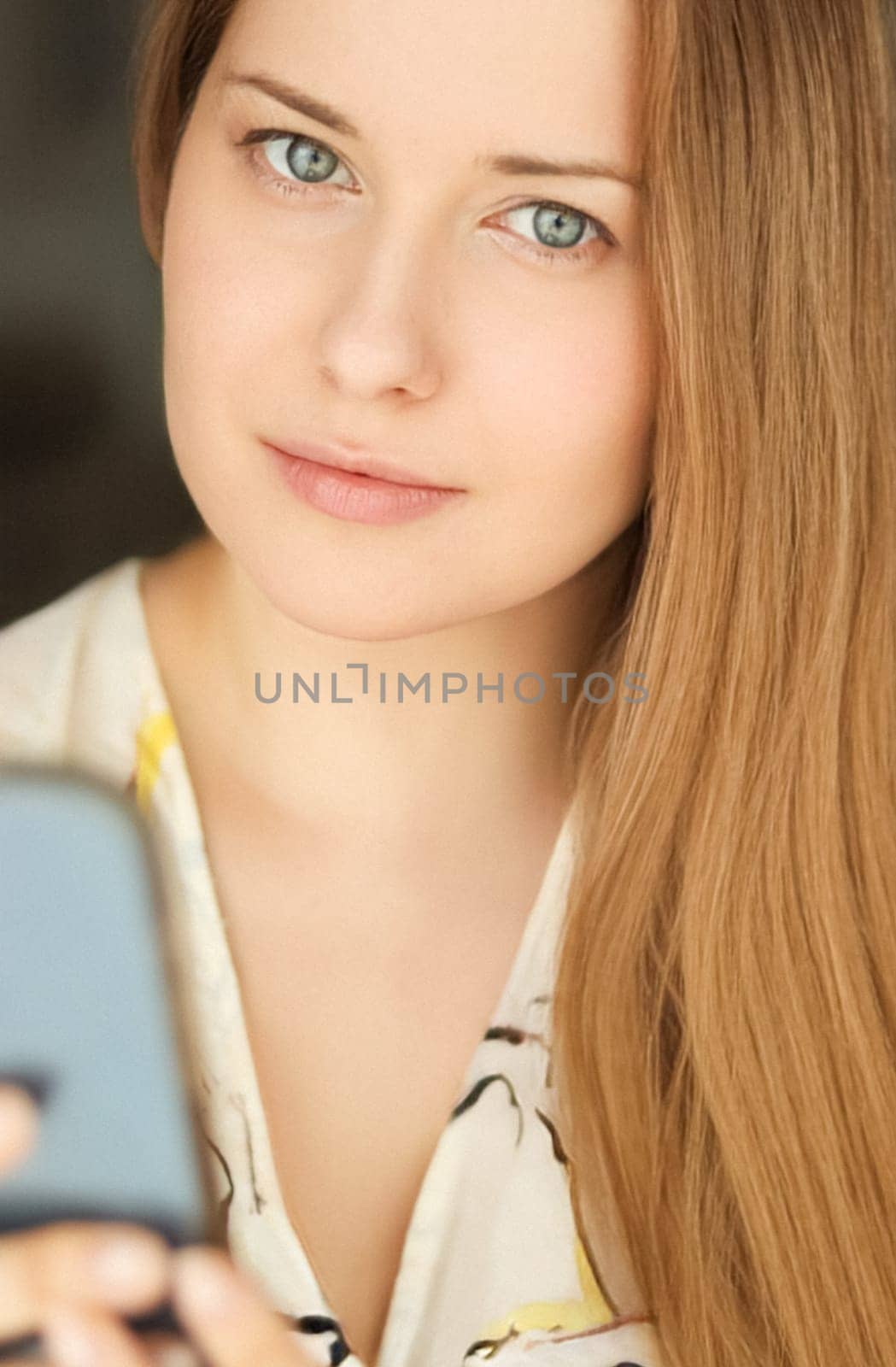 Beautiful happy woman using her mobile phone for online shopping and smiling, face portrait with natural make-up and casual lifestyle at home by Anneleven