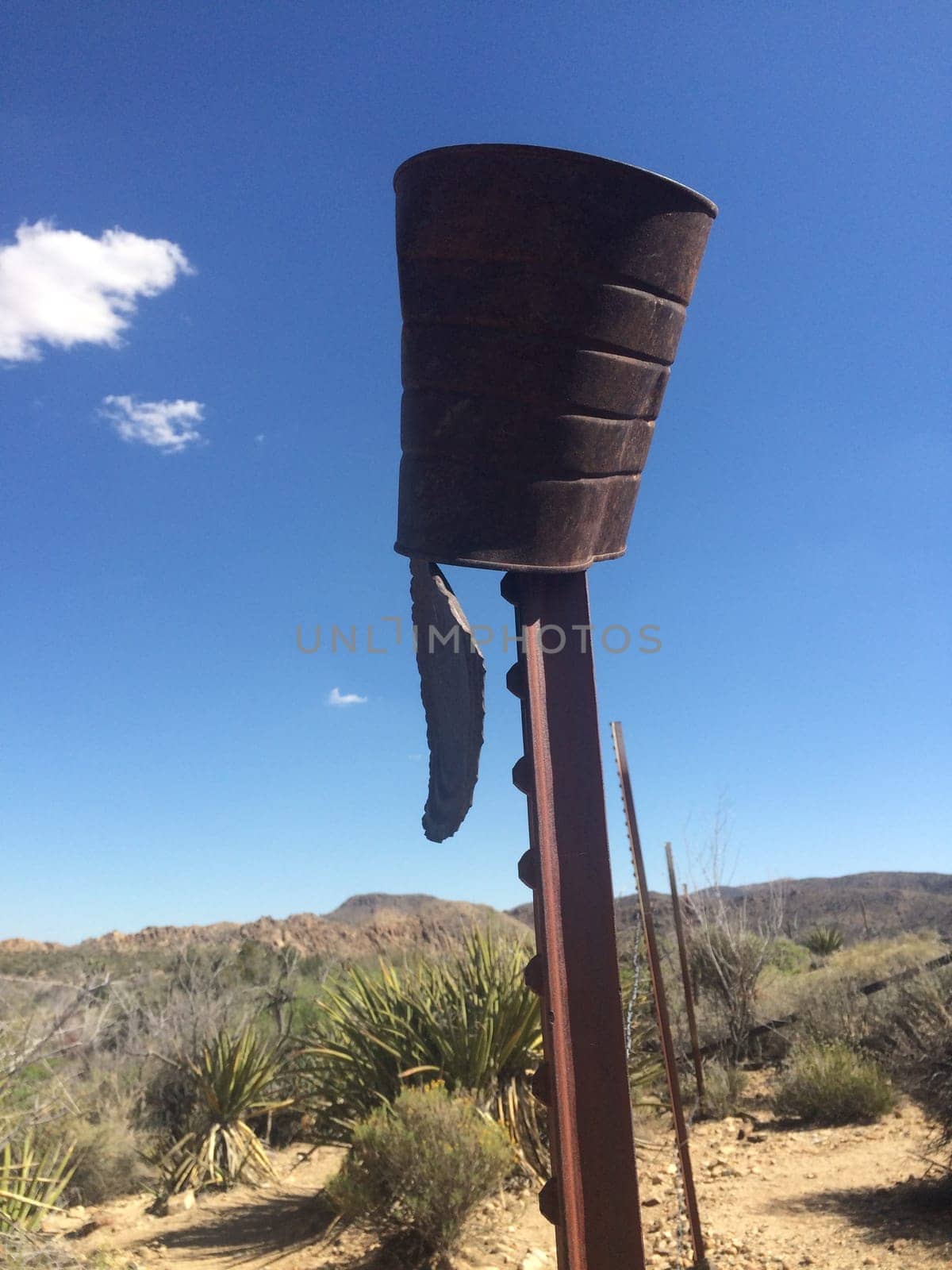 Rusty Old Can Upside Down on Post in Desert . High quality photo