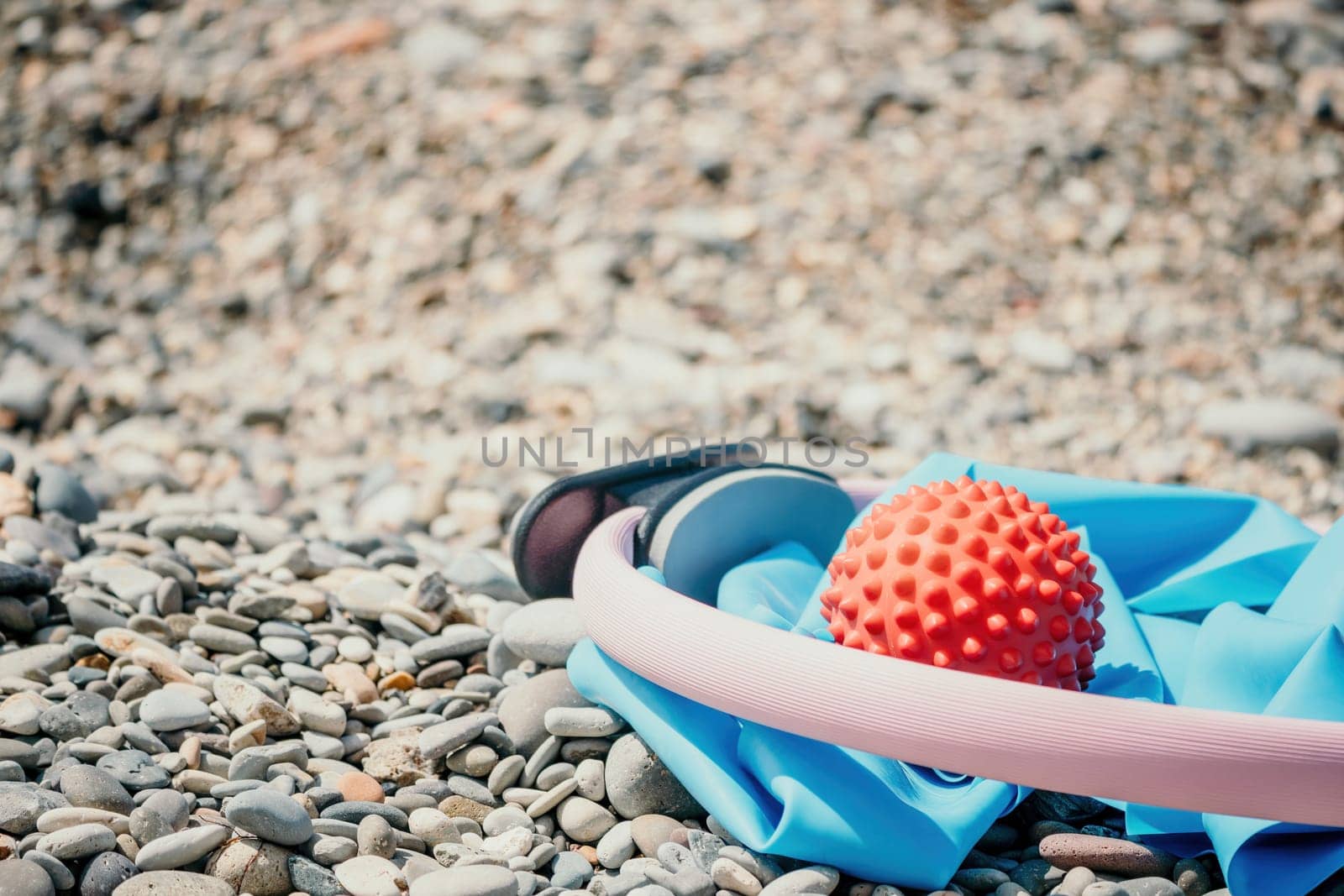 Pilates magic ring and rubber band on yoga mat near sea. Female fitness yoga concept. Healthy lifestyle harmony and meditation. by panophotograph