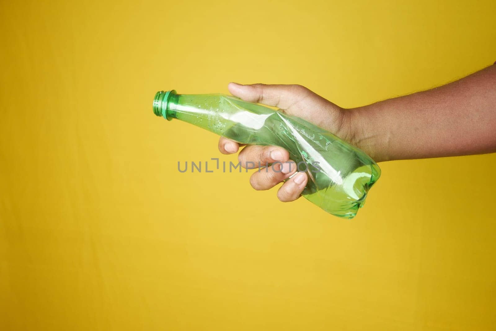 A person is grasping a plastic bottle with their fingers and thumb by towfiq007
