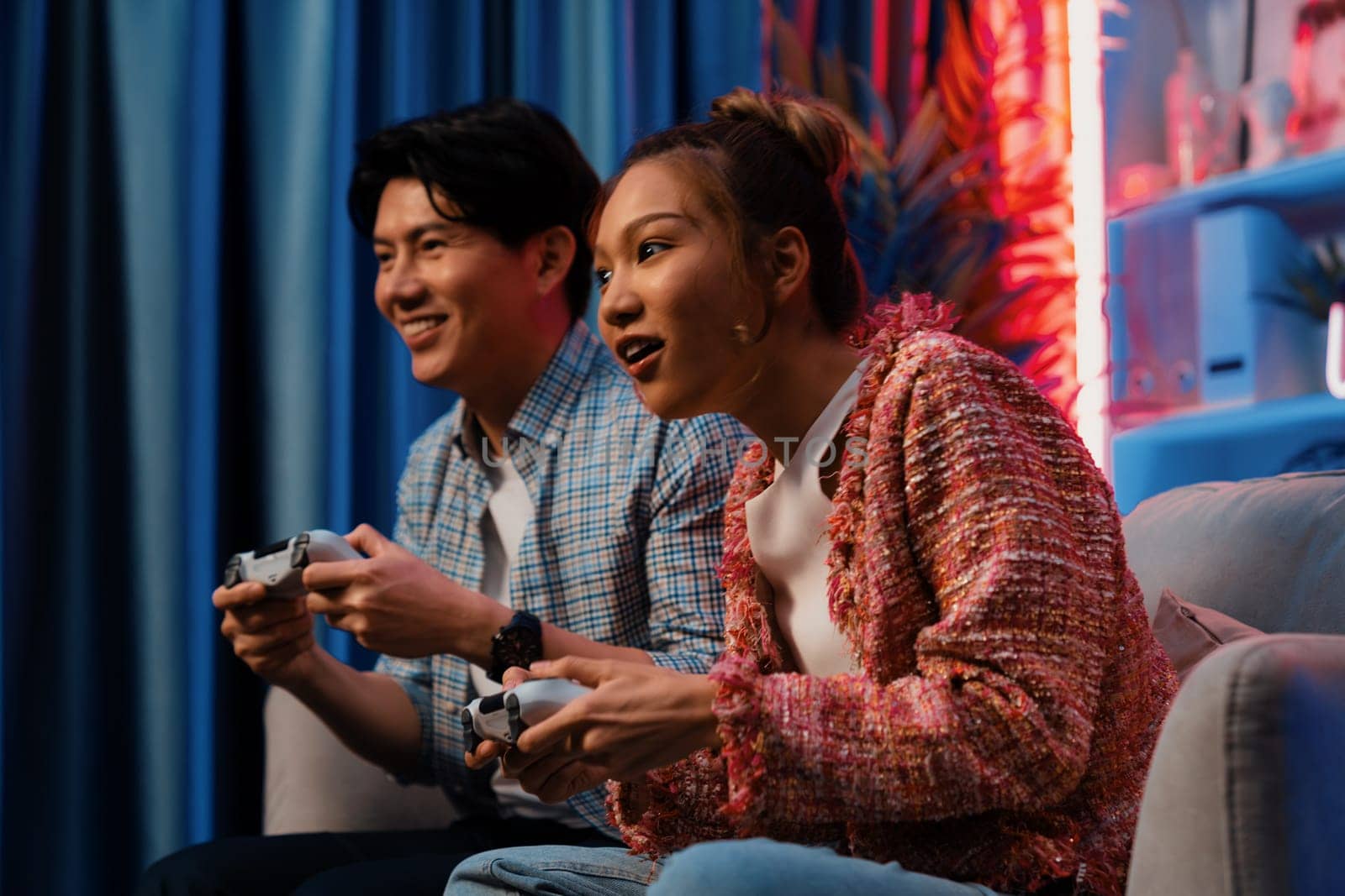 Smiling couple playing video game control by joystick fronted snack. Infobahn. by biancoblue