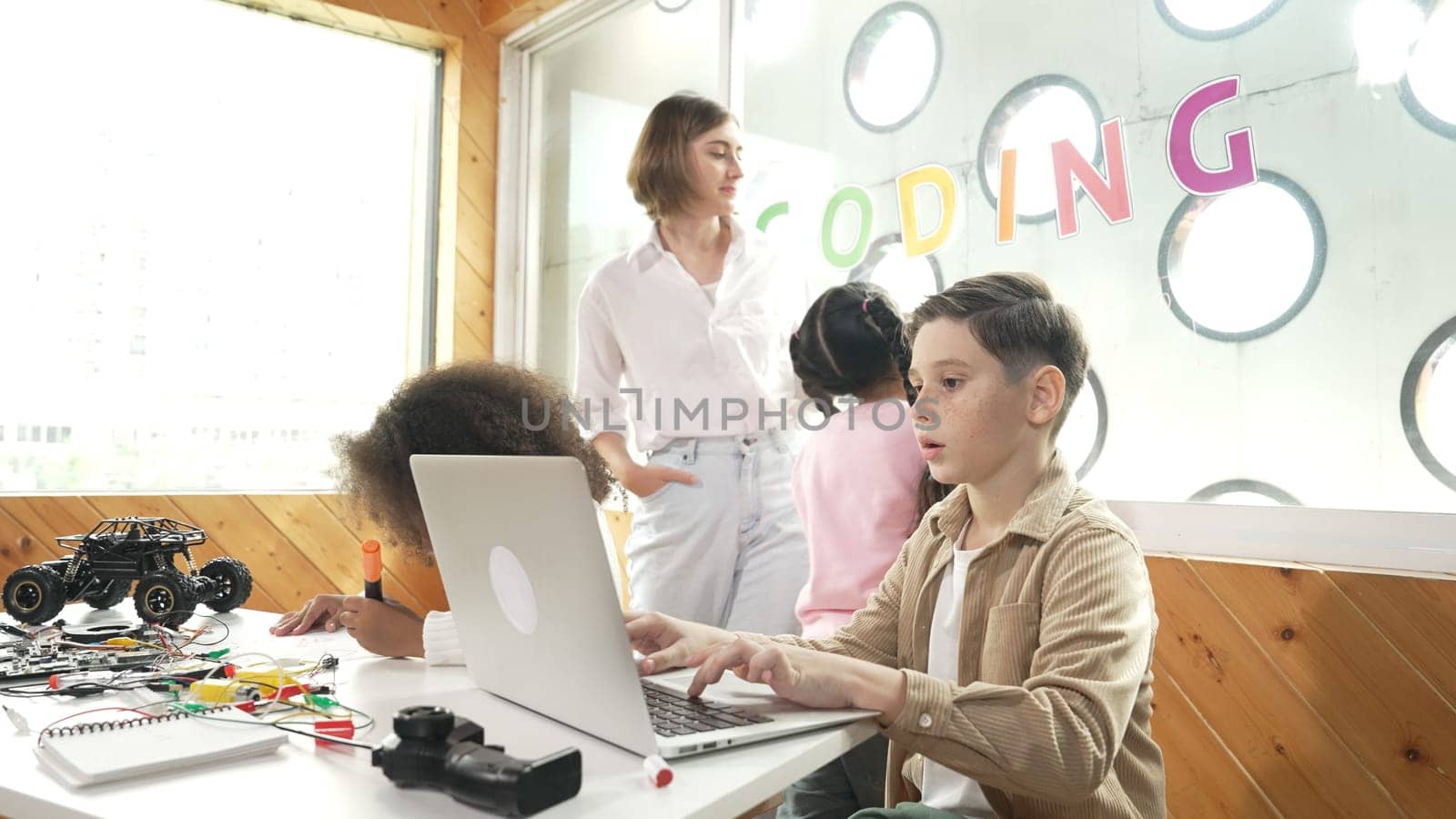 Smart teacher teaching and looking student using laptop at classroom. Professional instructor explained about programing engineering code or prompt while studying and learning program. Erudition.