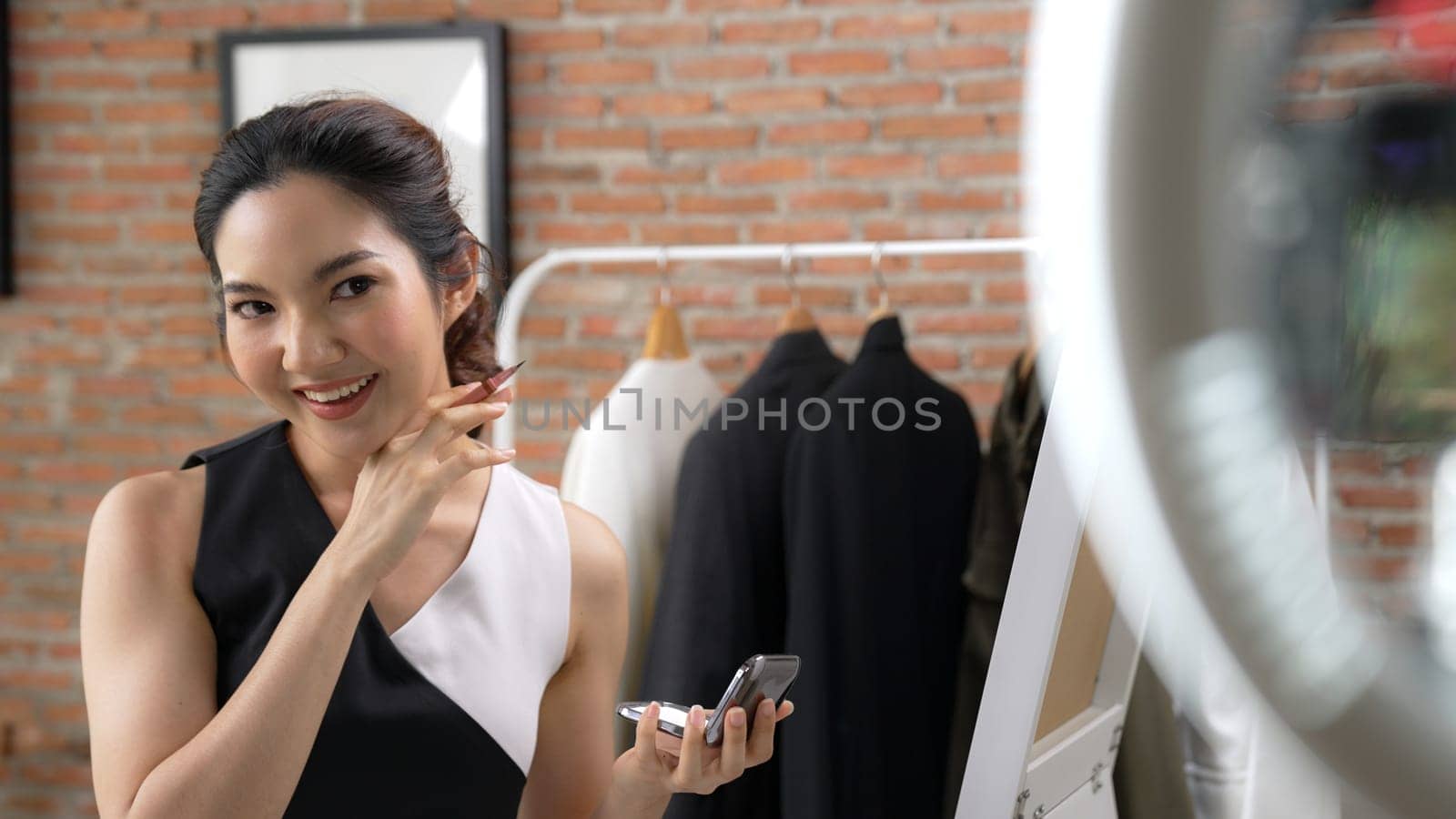 Woman influencer shoot live streaming vlog video review vivancy makeup social media or blog. Happy young girl with cosmetics studio lighting for marketing recording session broadcasting online.