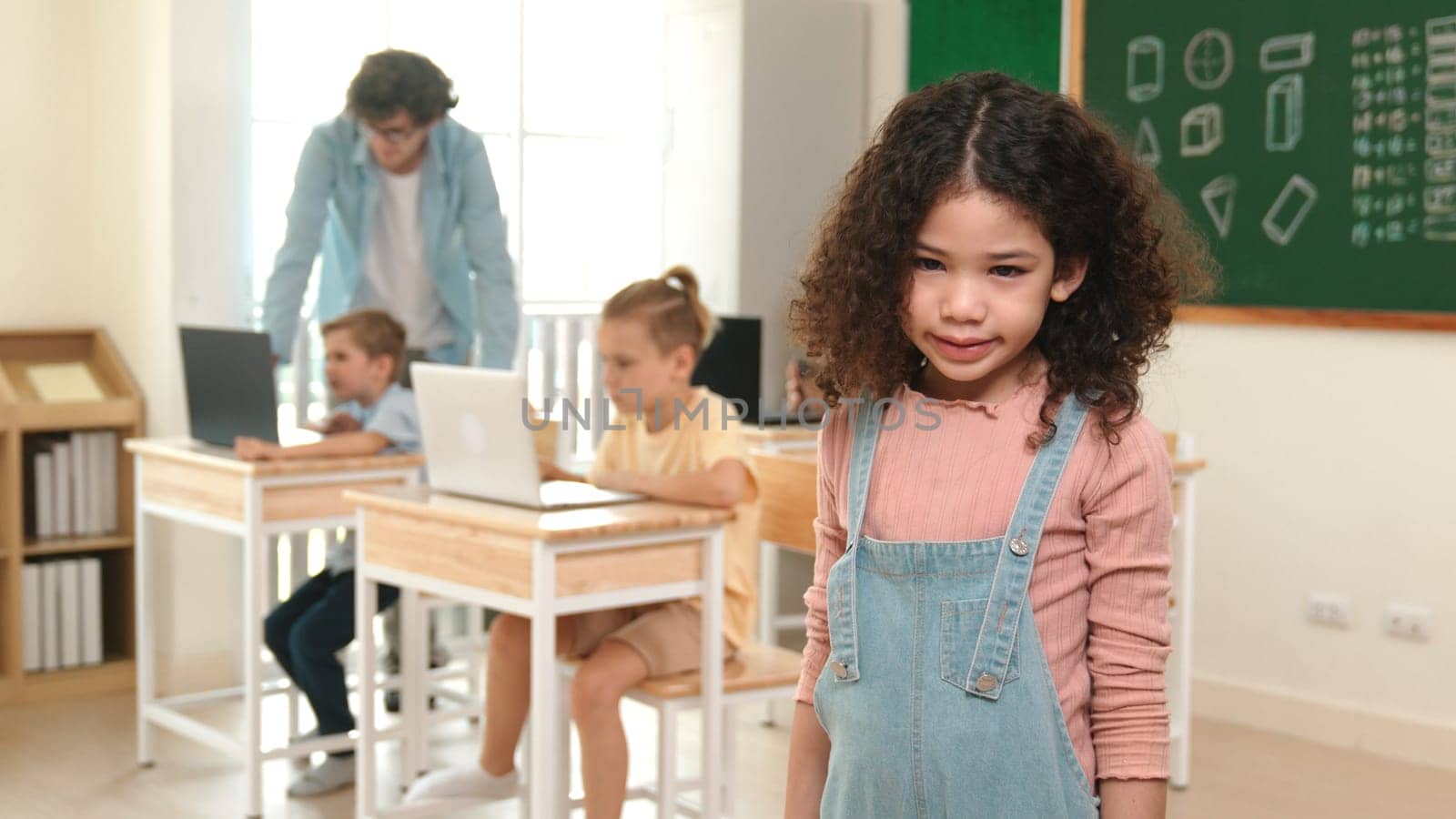 Caucasian energetic girl looking at camera while friend studying about writing engineering code or coding prompt. Skilled smart teacher checking prompt while teaching about AI generated. Pedagogy.