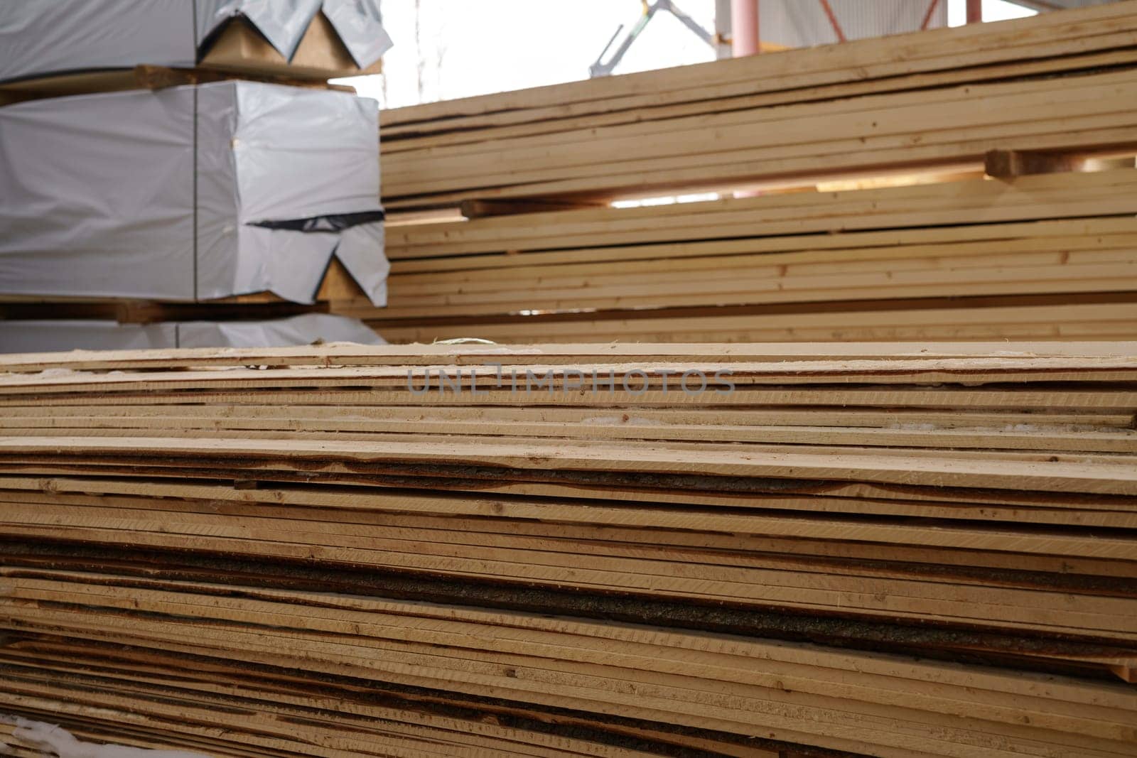 Image of wooden boards piled at sawmill by rivertime