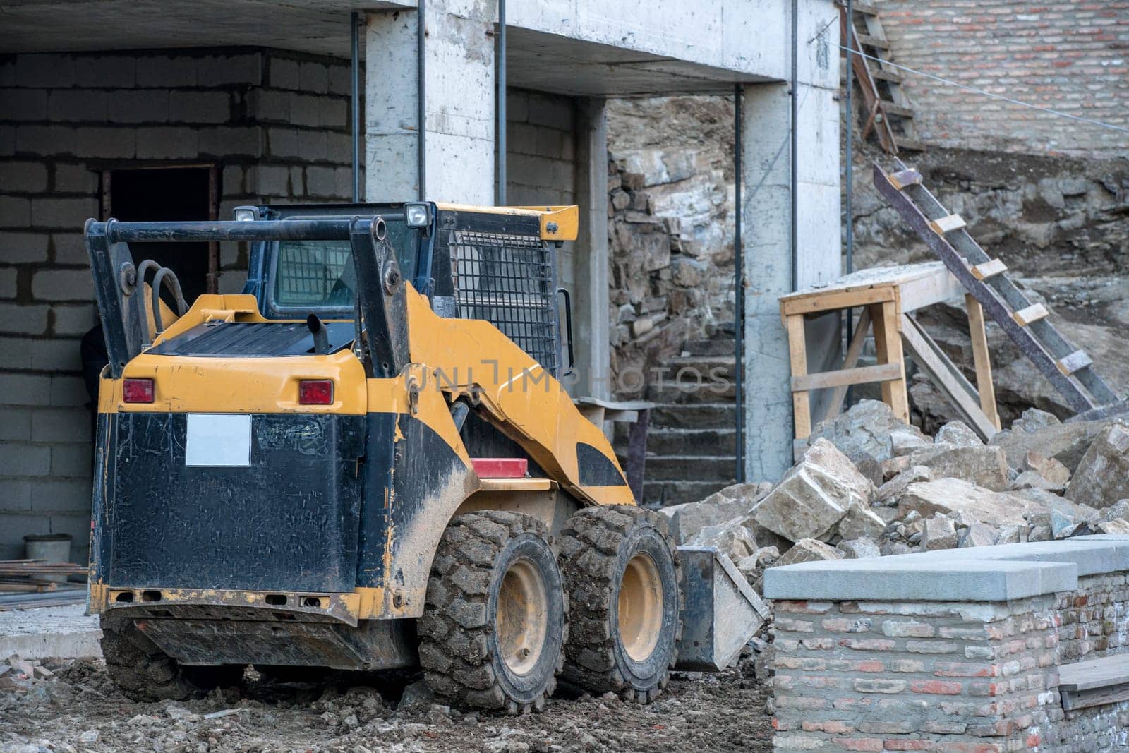 Skid loader working on building construction by rivertime