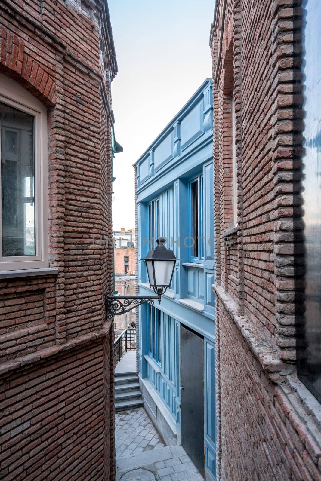 Narrow street and lantern on wall of building by rivertime