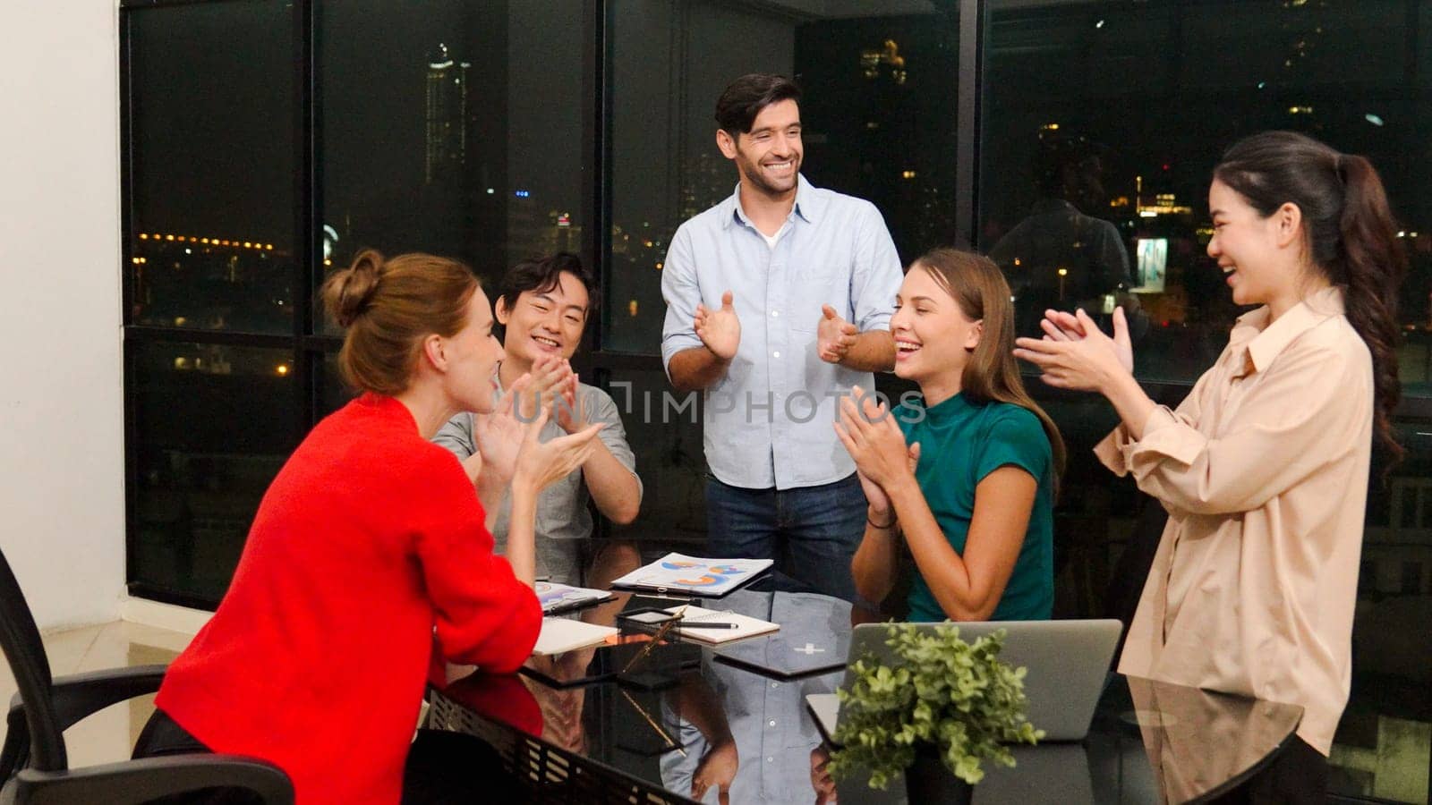 Businesspeople putting hands together and clapping hands to celebrate successful project at modern office with night city view. Group of manager with stacks of hands. Teamwork, trust. Tracery