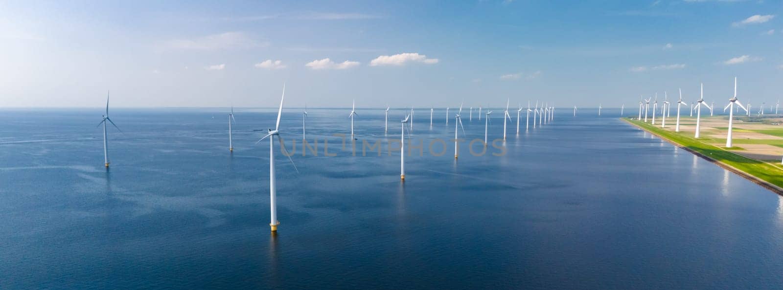 A vast body of water in Flevoland, with numerous towering windmills dotting the landscape.