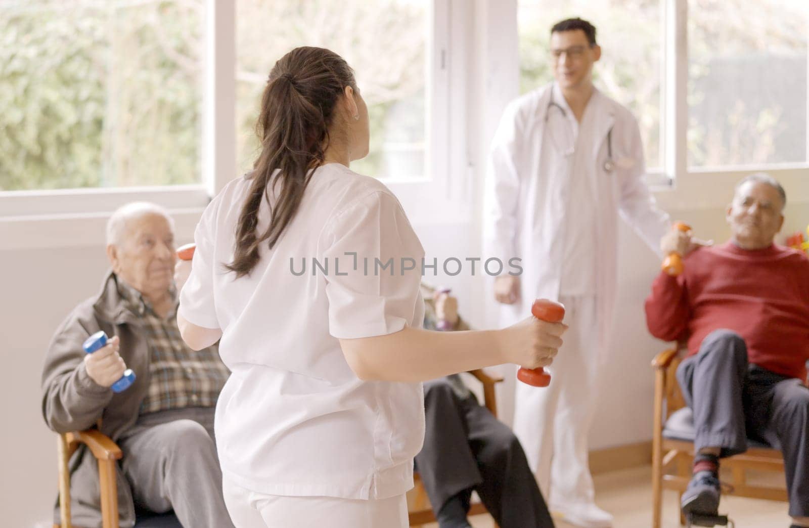 Physiotherapist explaining the exercises to a group of seniors by ivanmoreno