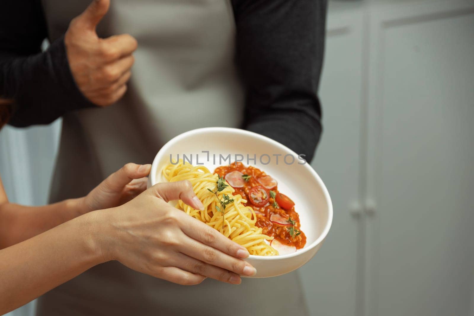 Close up of hand couple chef influencers completely cooked spaghetti with meat topped with tomato sauce special dish on live chanel. Concept of serving healthy food at modern home studio. Postulate.