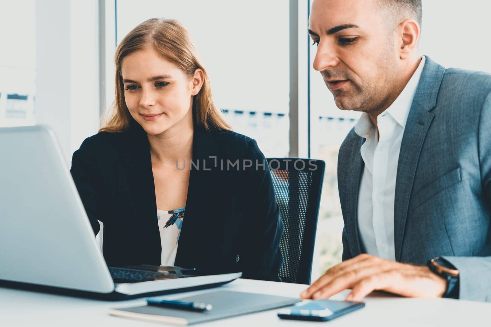 Businessman executive is in meeting discussion with a businesswoman worker in modern workplace office. People corporate business team concept. uds