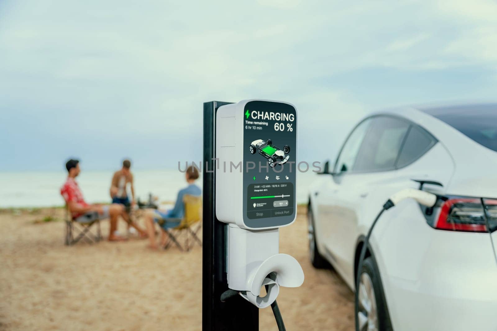 Alternative family vacation trip traveling by the beach with electric car recharging battery from EV charging station with blurred family enjoying the seascape background. Perpetual