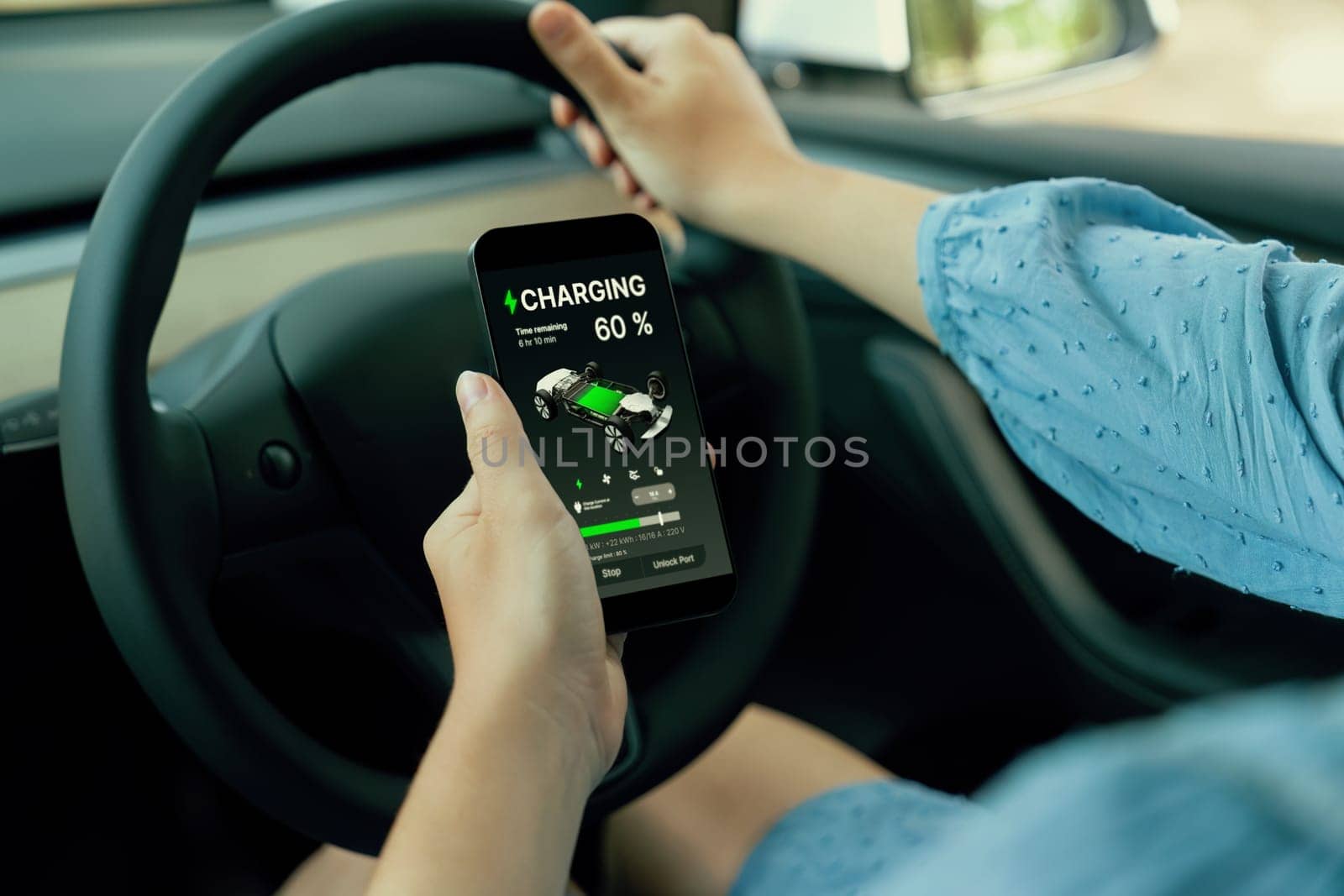 Eco-conscious woman on driver seat checking EV car's battery. Perpetual by biancoblue