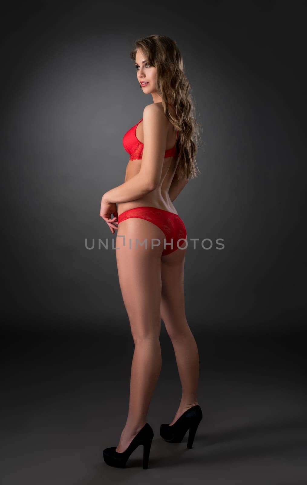 Sexy girl posing in red lingerie and high-heeled shoes