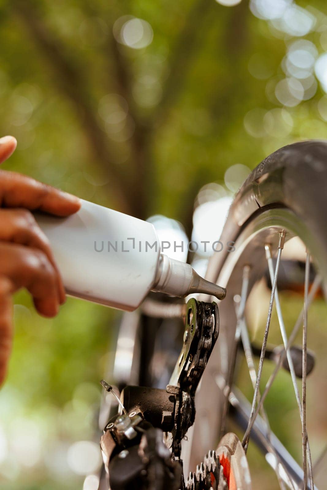 Hand holding chain lubricant for bicycle by DCStudio