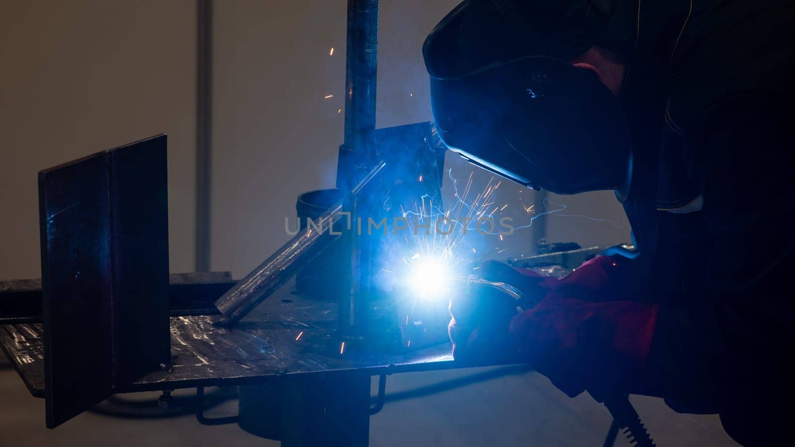 Competitions among welders. A man in a protective mask is welding