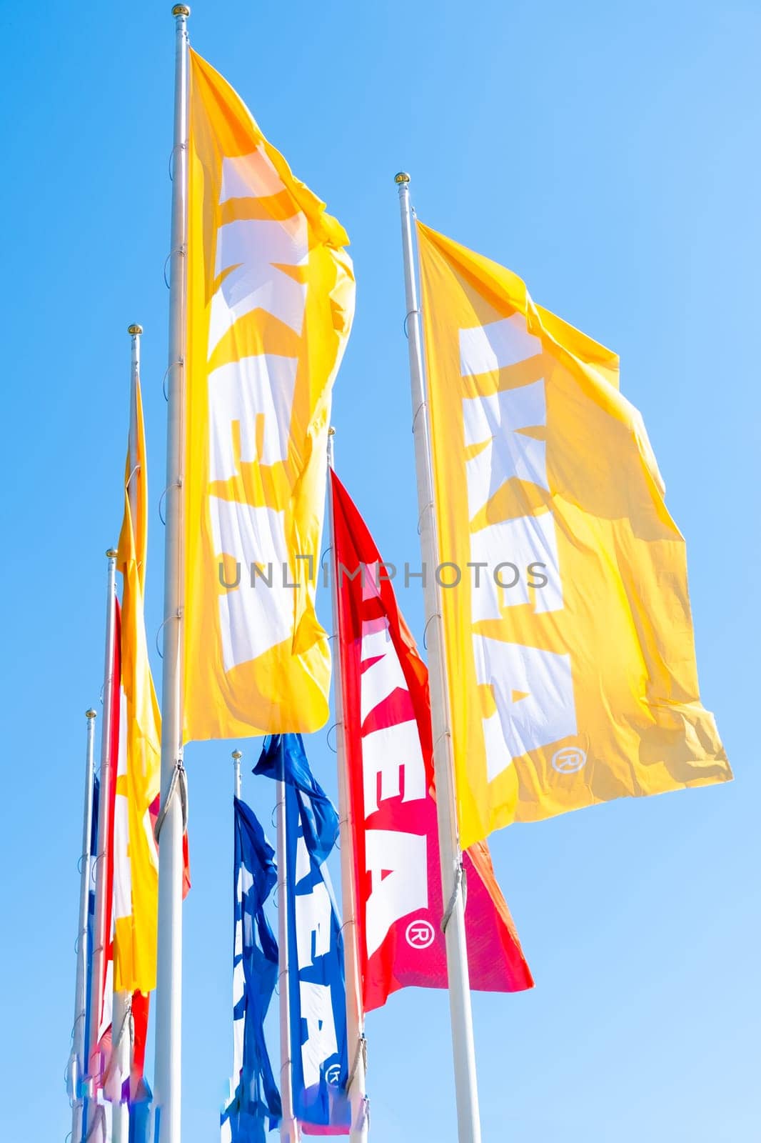 Different colors IKEA flags against blue sky by vladimka