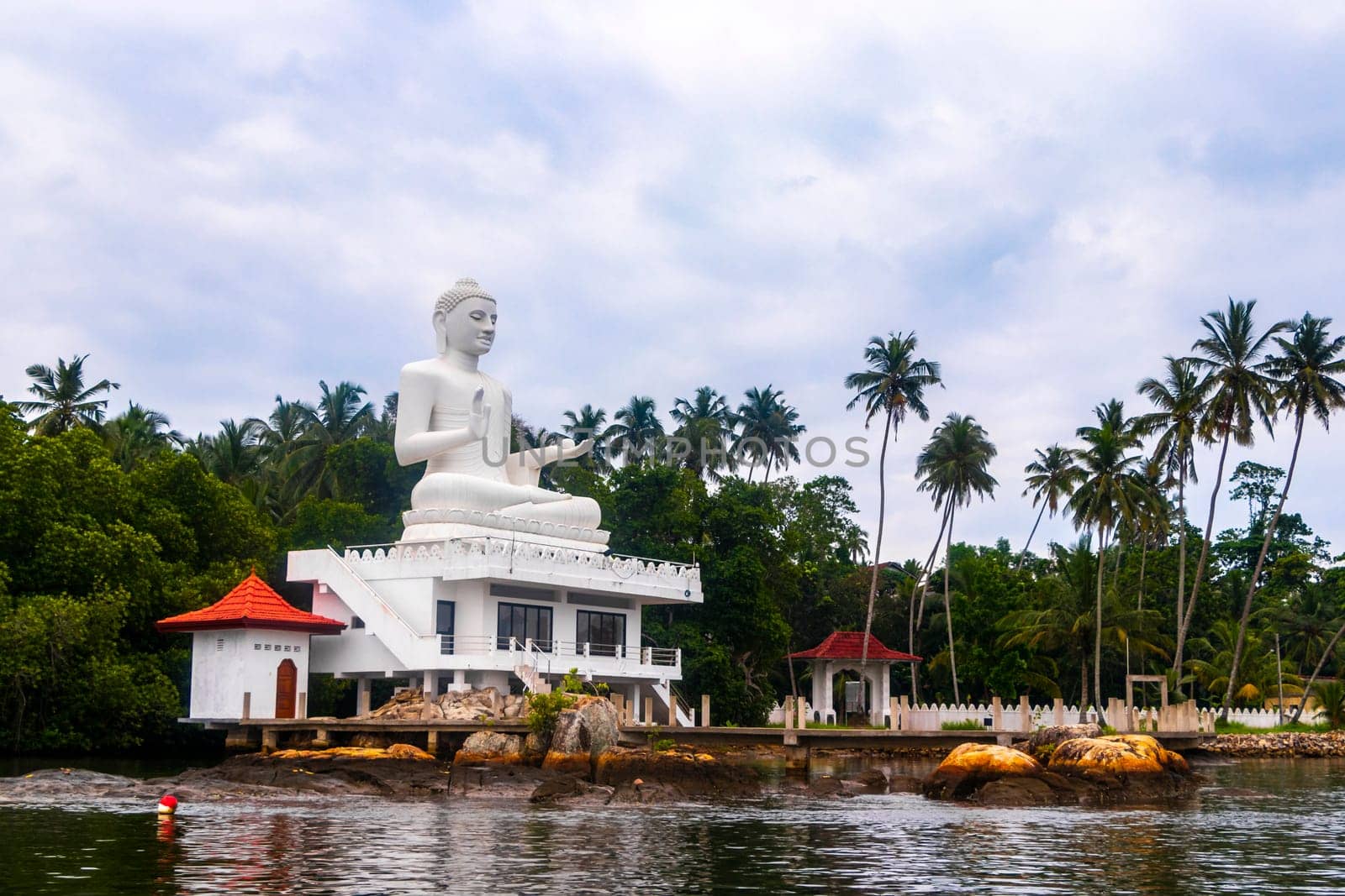 Large white Buddha statue in Bentota Udakotuwa Temple at Bentota Ganga in Bentota Beach Galle District Southern Province Sri Lanka.
