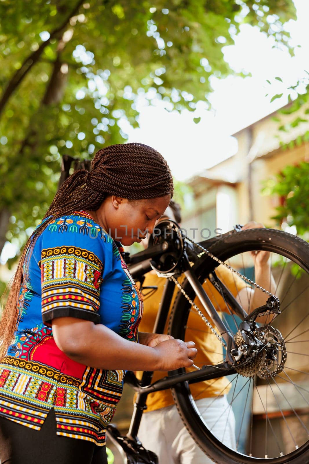 African american woman fixing bicycle by DCStudio