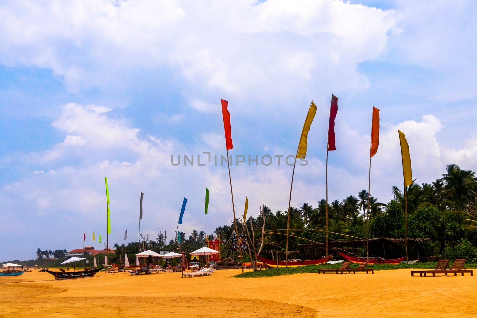 Beautiful beach with tropical nature sand water waves people fun parasols and sun loungers in Bentota Beach on Sri Lanka island.