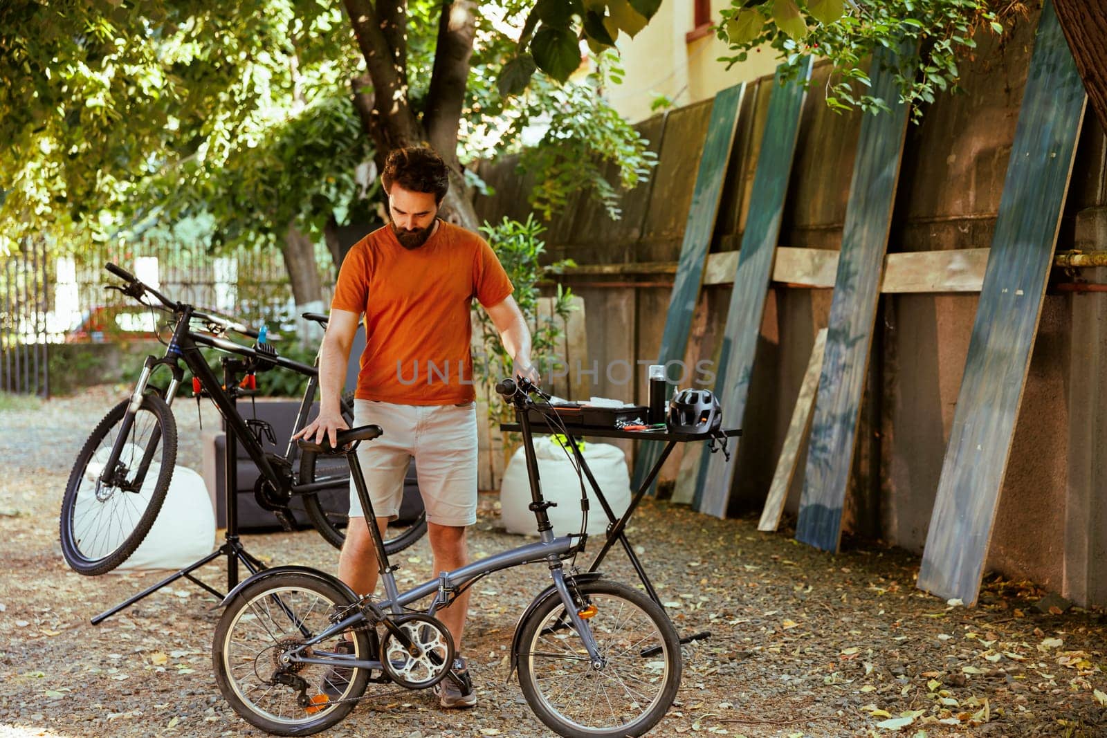 Man ensuring bicycle safety in yard by DCStudio