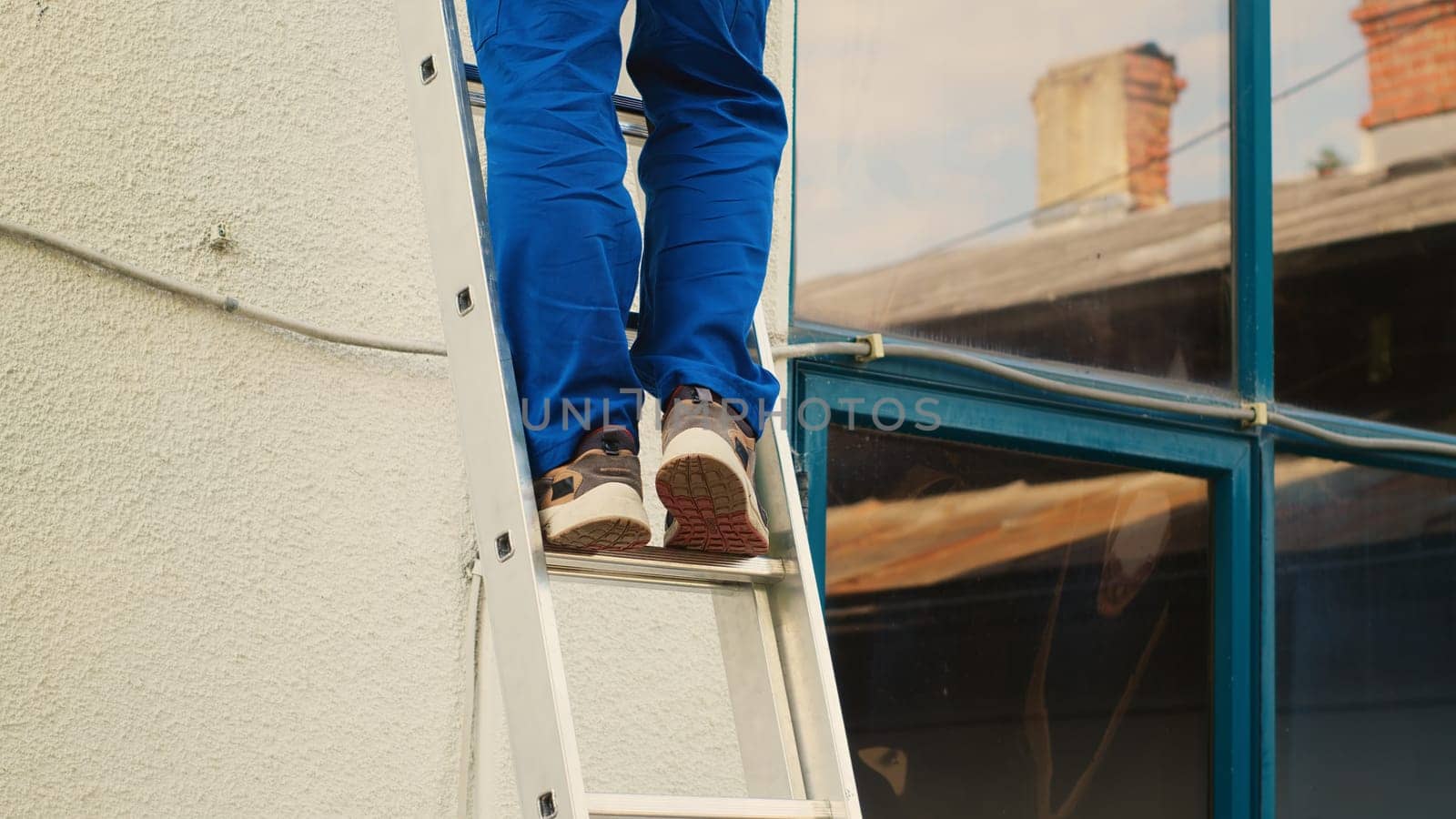 Technician holds drill climbing ladder by DCStudio