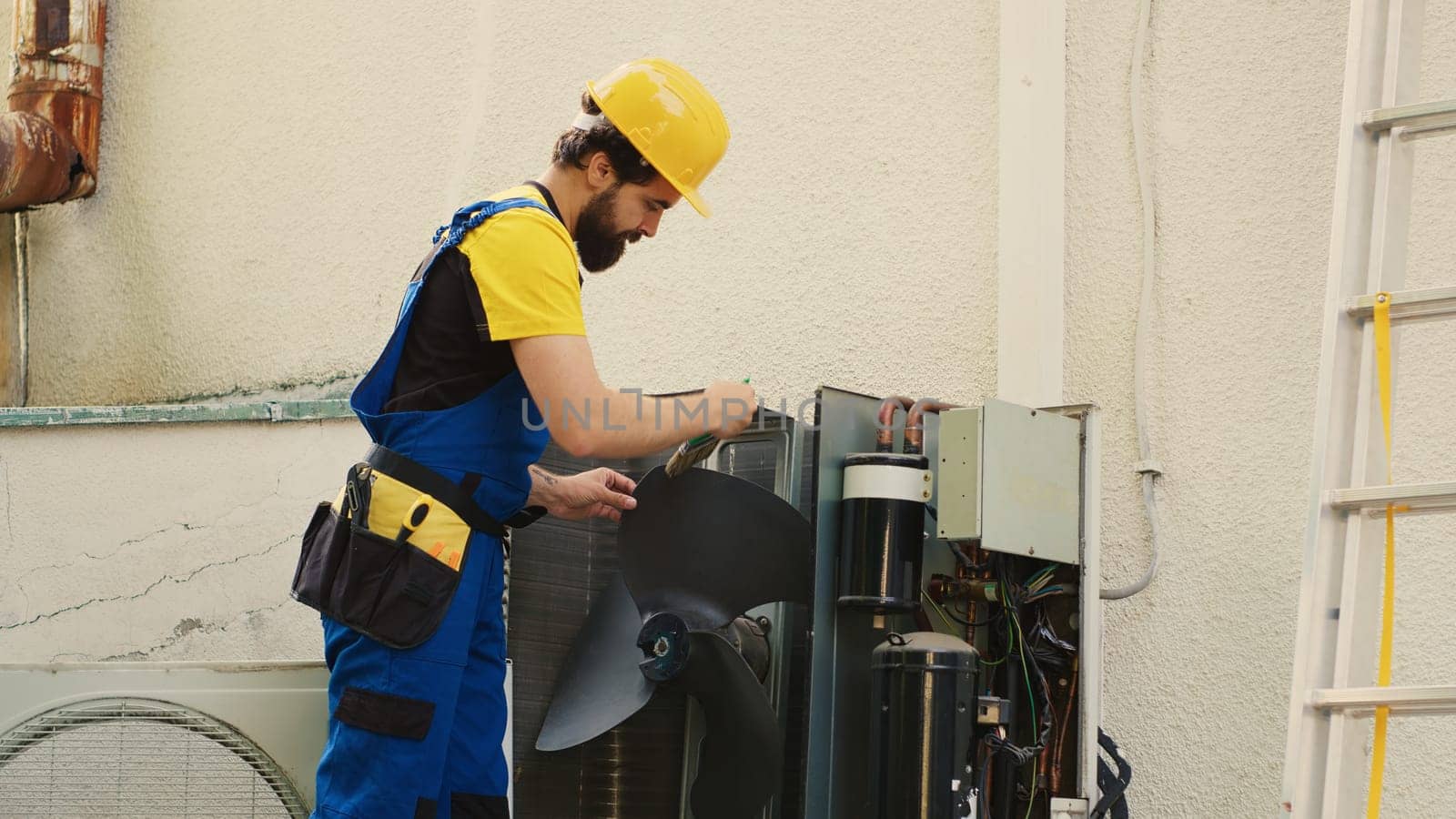 Meticulous technician removing layer of dust from blower fan to prevent ventilation system failure. Adept repairman cleaning internal components to stop risk of HVAC system overheating