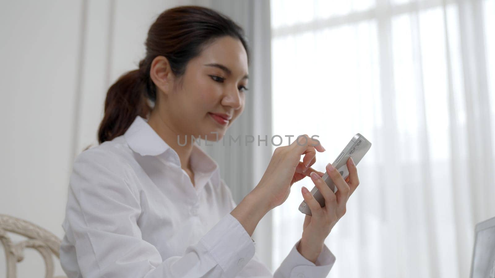 Young woman using smartphone browsing for online shopping E commerce by online payment gateway at vivancy home. Modern and convenience online purchasing make secure and convenient purchases.