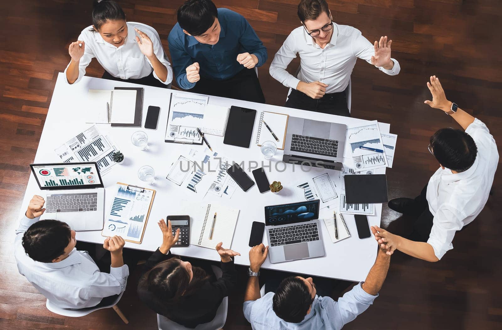 Top view meeting table, excited and happy office worker celebrate after make successful strategic business marketing planning. Teamwork and positive attitude create productive workplace. Prudent