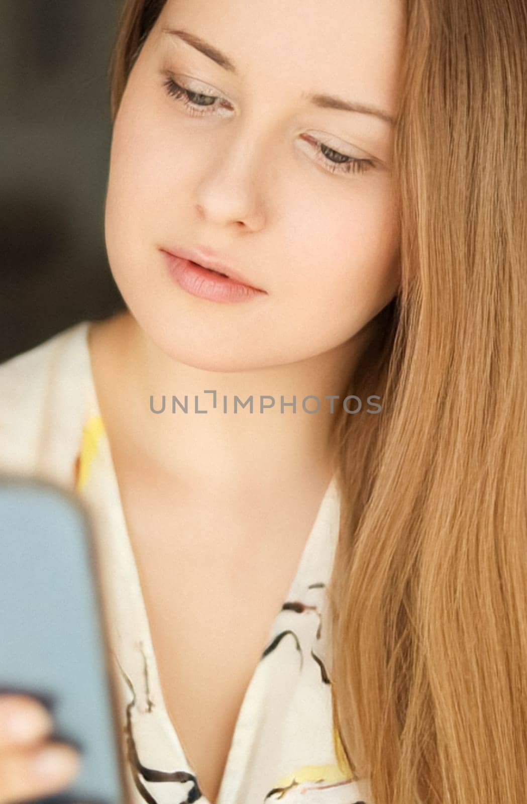 Beautiful happy woman using her mobile phone for online shopping and smiling, face portrait with natural make-up and casual lifestyle at home concept