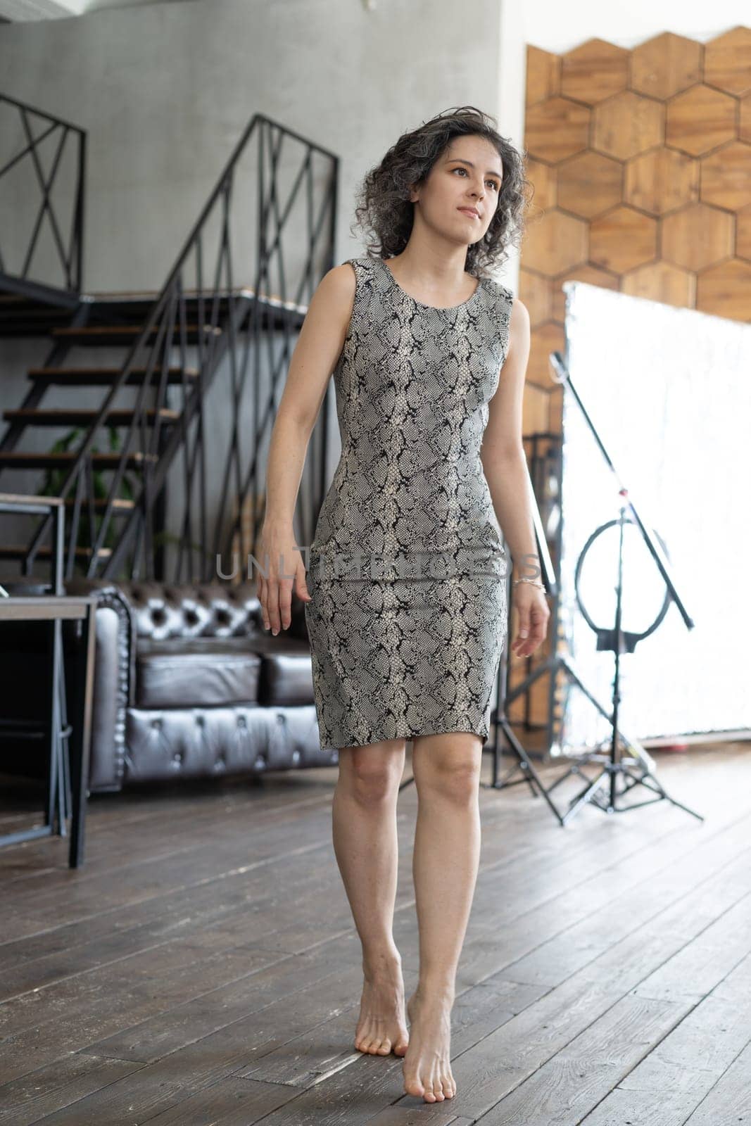 young beautiful woman posing in a short dress in the studio