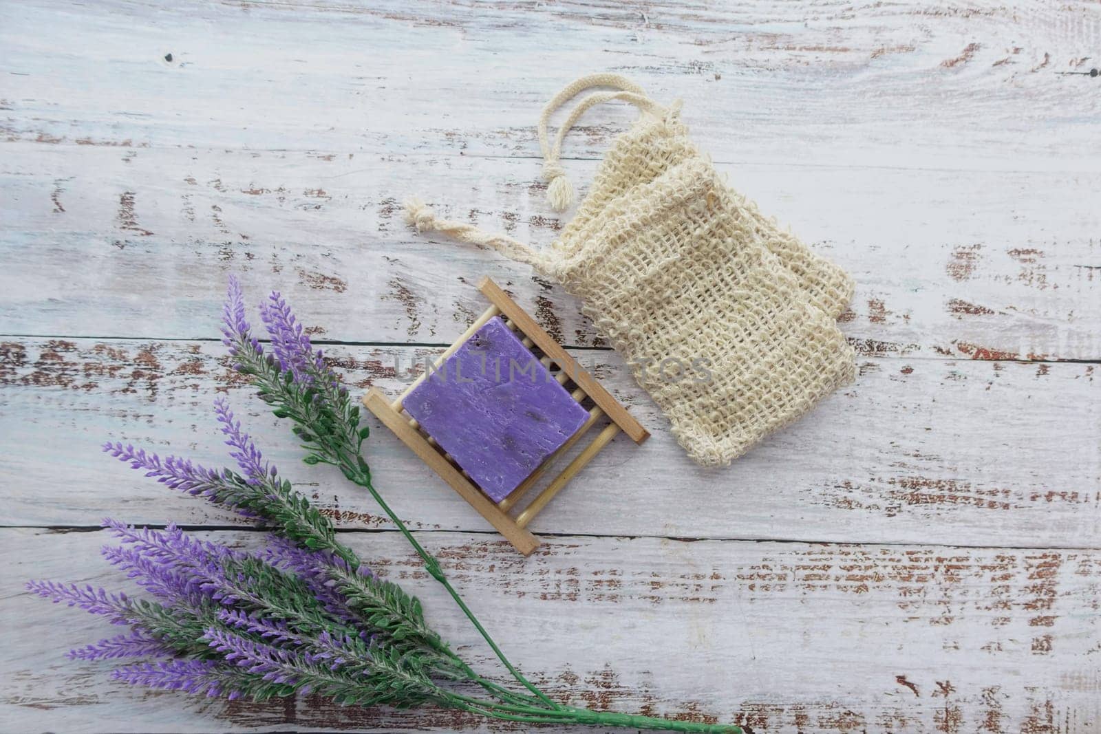 Homemade natural soap bar and lavender flower on table .