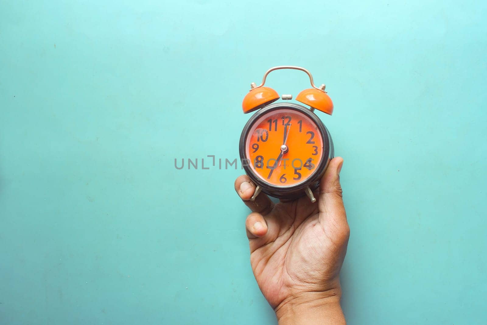 man hand holding alarm clock color background ,,