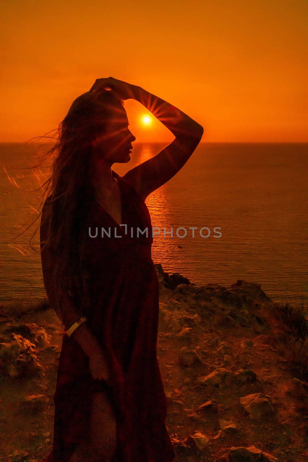 Woman sunset sea red dress, portrait happy beautiful sensual woman in a red long dress posing above the sea on sunset