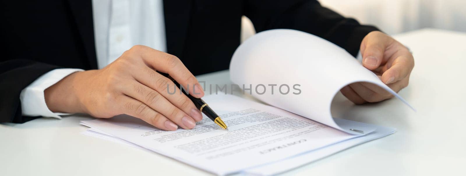 Business executive signing contract agreement document on the bale with the help from company attorney or lawyer service in law firm office. Business investing and finalizing legal processing. Shrewd