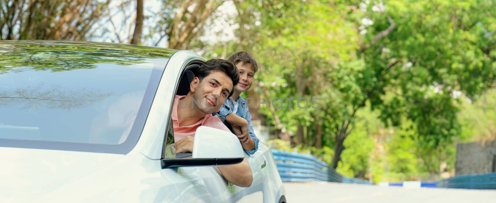 Dad and son on the road trip by the green nature countryside, family vholiday vacation concept. Young little boy enjoying family car adventure vacation with his father. Perpetual