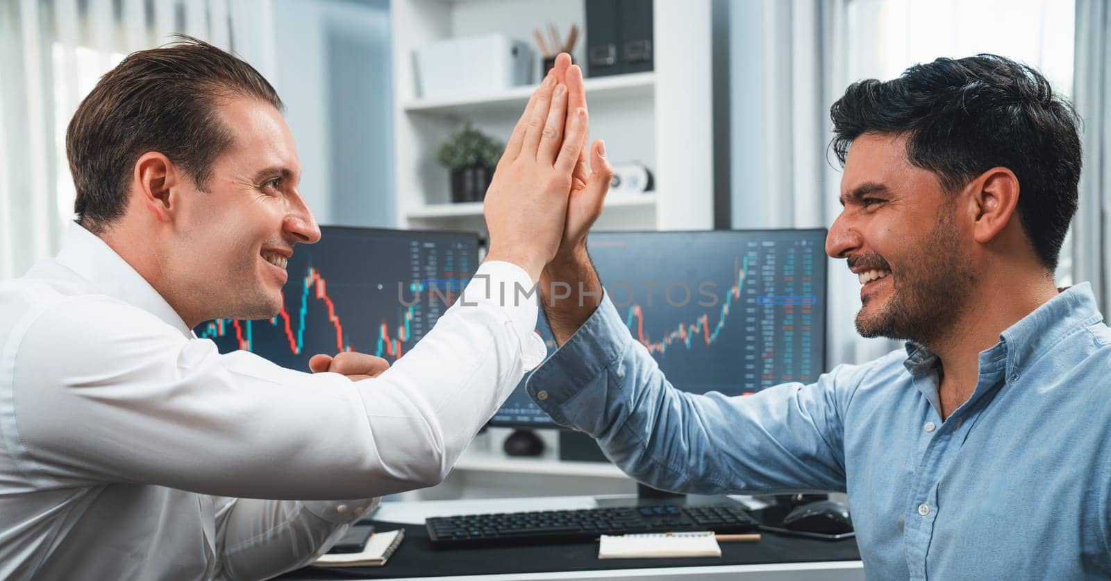 Cheerful two smiling stock exchange traders giving high five. Sellable. by biancoblue